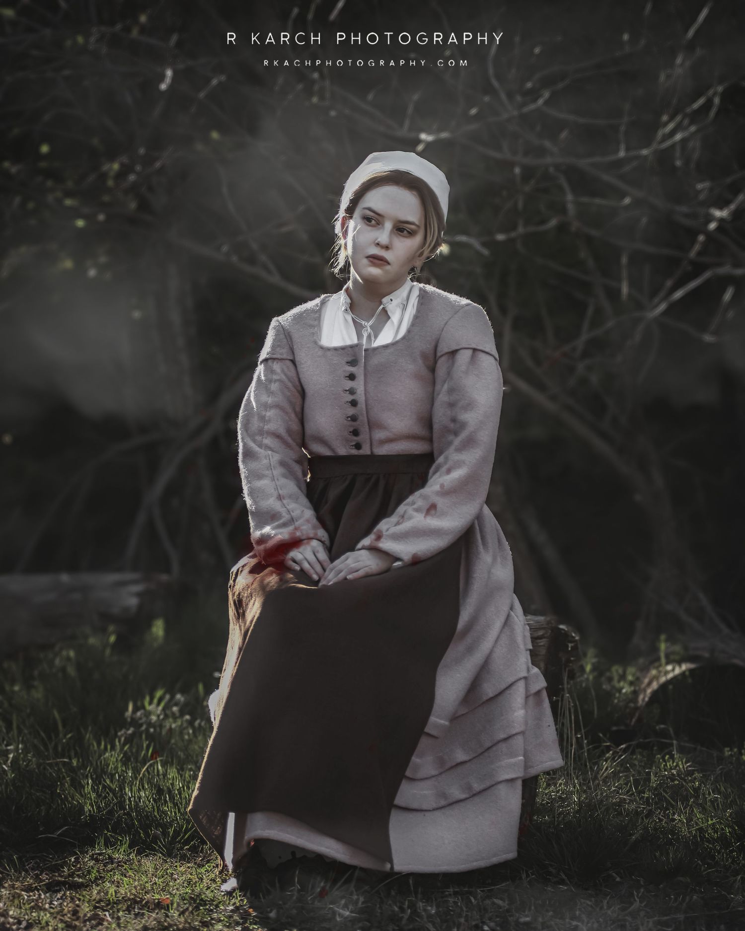 Period costume portrait of figure in gray pilgrim dress against moody natural background.