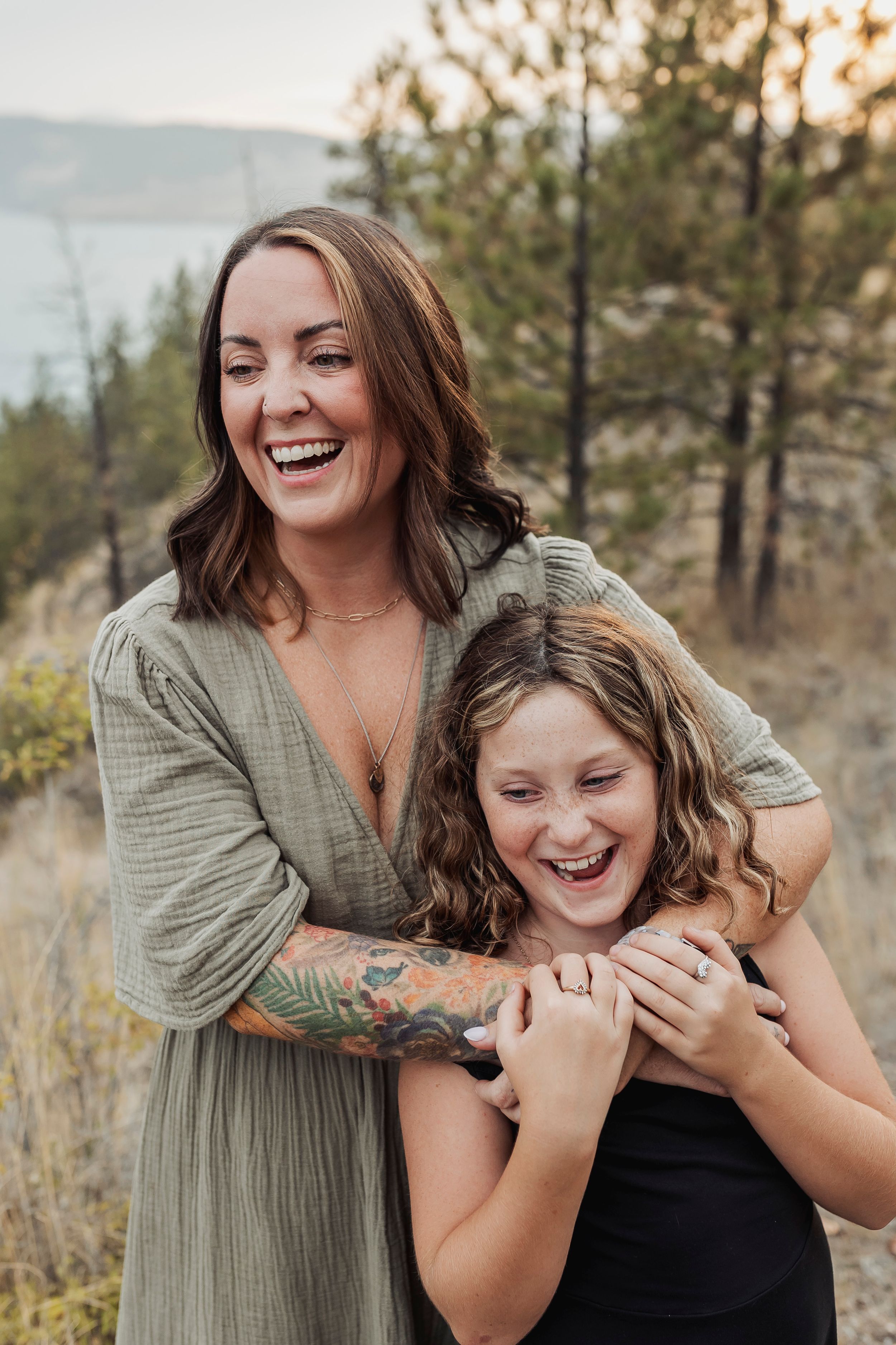 Joyful moment captured between two people laughing against mountain backdrop.