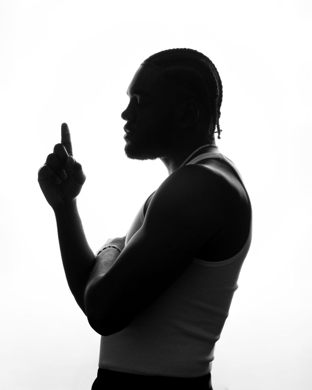 Black and white silhouette portrait of man in tank top pointing finger upward.