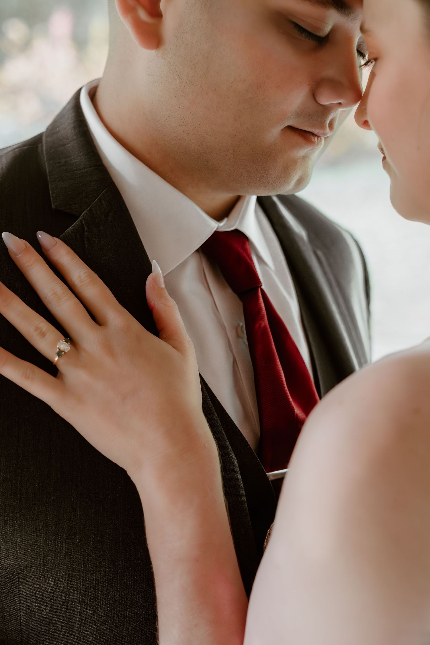 Intimate close-up of newlyweds sharing tender moment in formal attire.