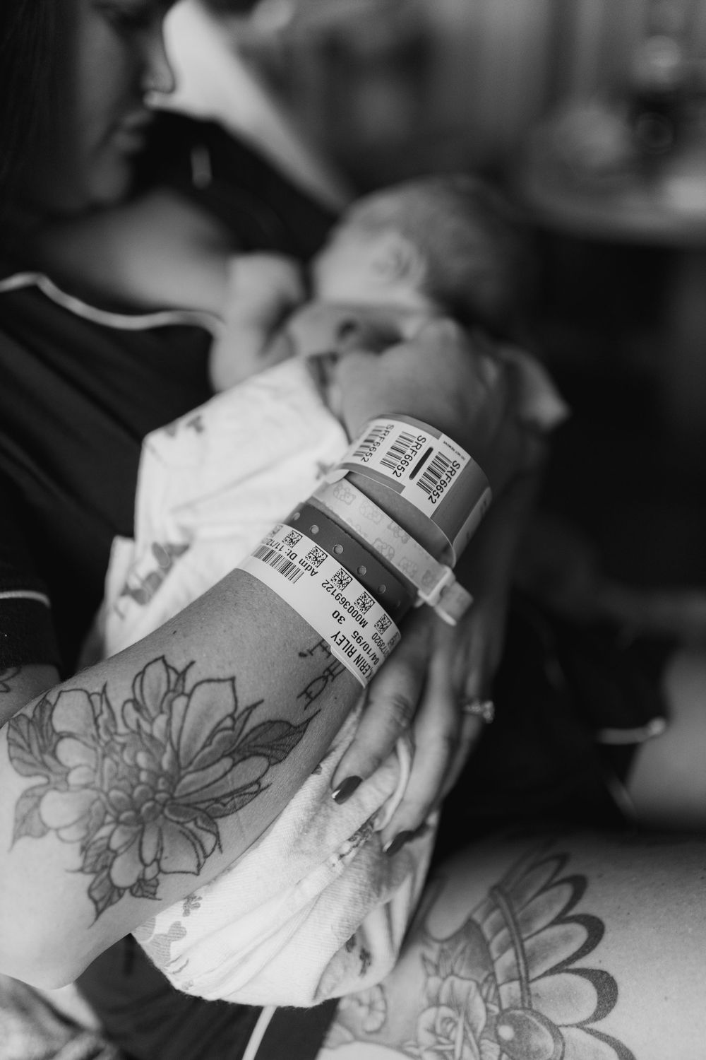 Black and white image showing hospital ID bracelet and floral tattoos.
