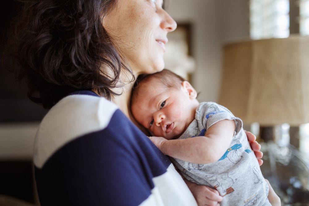 Everett WA baby photographer: A mother holds her newborn son at a photo session in Mukilteo WA