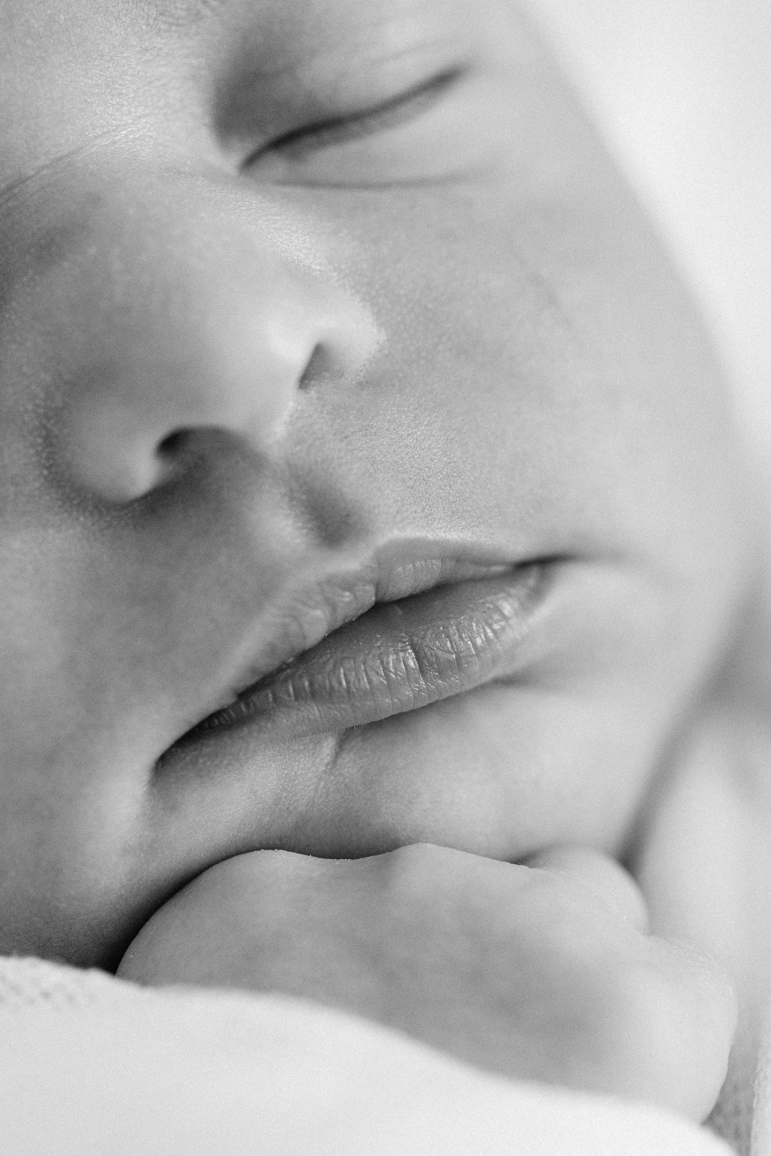 Artistic black and white macro photograph of soft infant lips in gentle sleeping expressions.