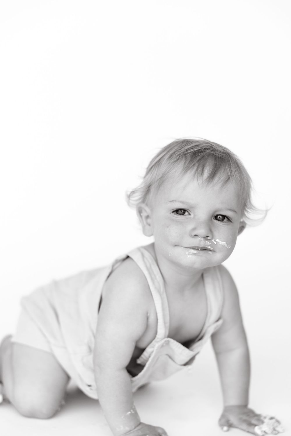 A black and white photo sequence shows a baby in a white diaper crawling and moving across a light background.