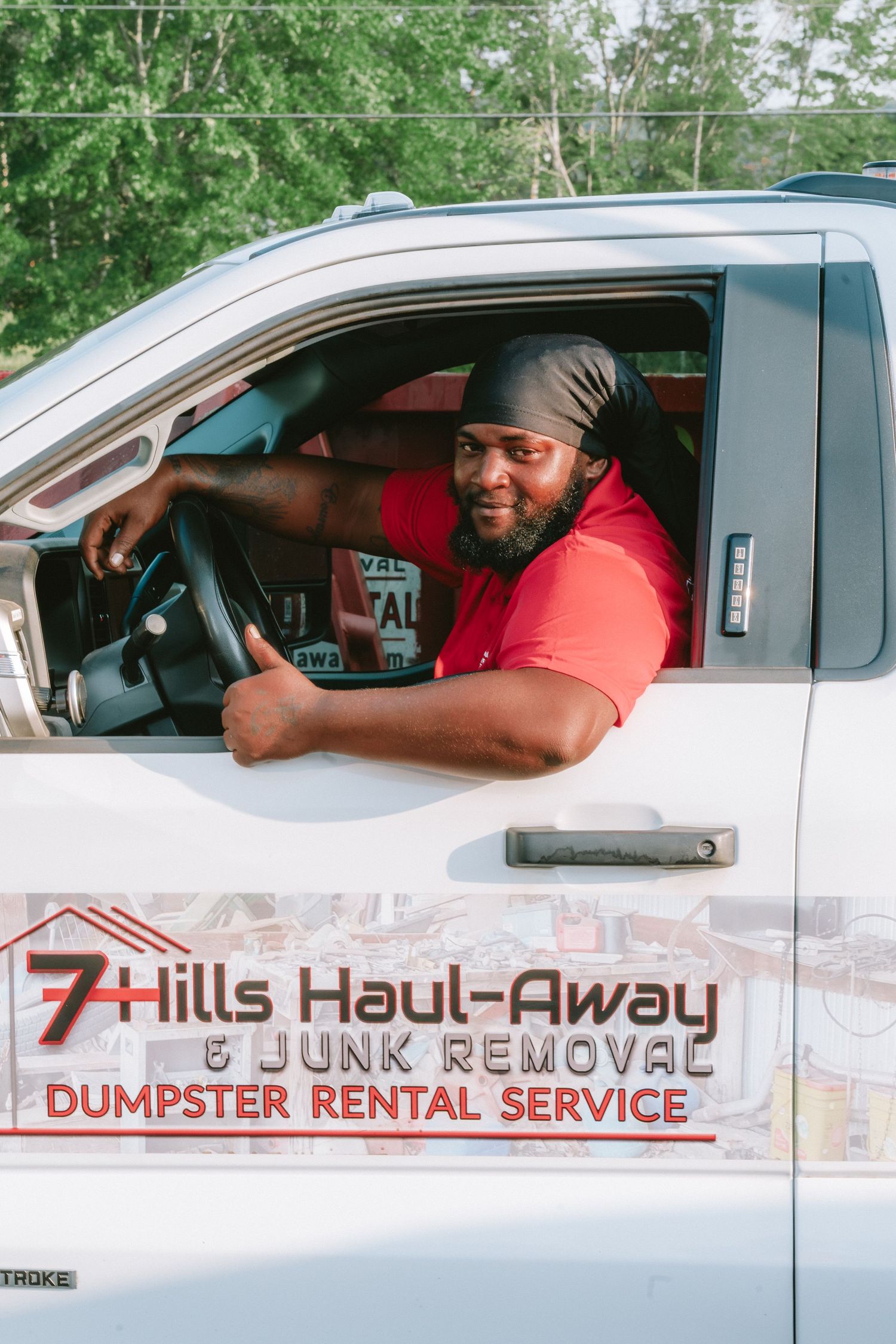 A delivery truck for 7 Hills Haul-Away & Junk Removal dumpster rental service is shown on a sunny day.