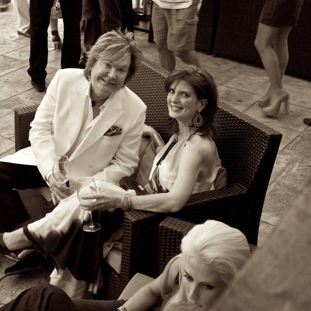 A vintage sepia-toned photograph showing people seated in wicker chairs at a Dallas social gathering.