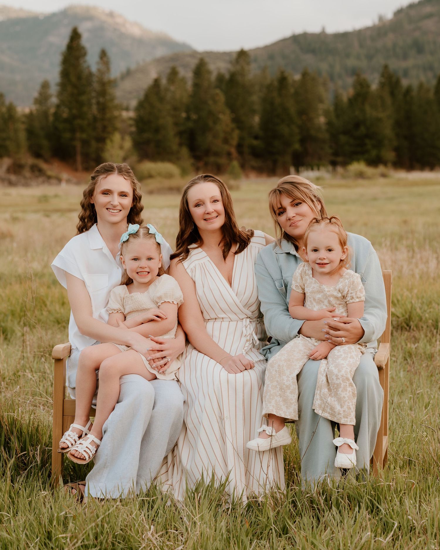 Family walking together on grassy field during golden hour.