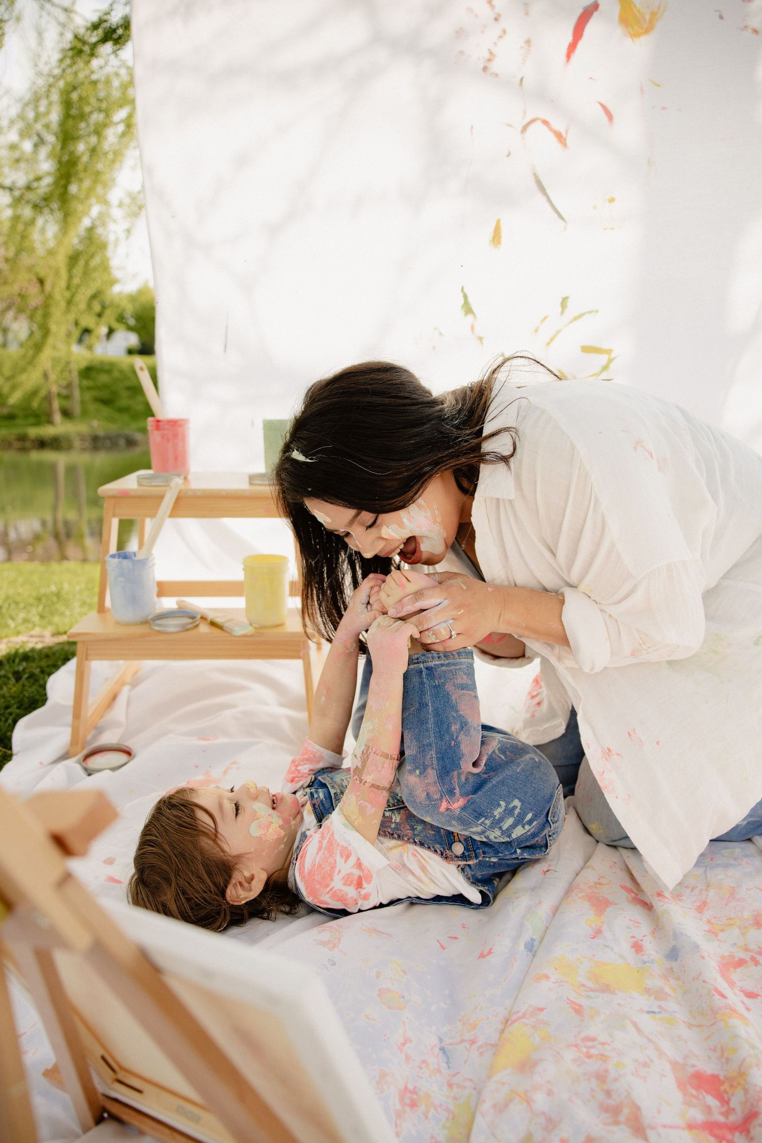 A tender moment shared between two people playing and laughing on a blanket outdoors on a sunny day in Frederick Maryland
