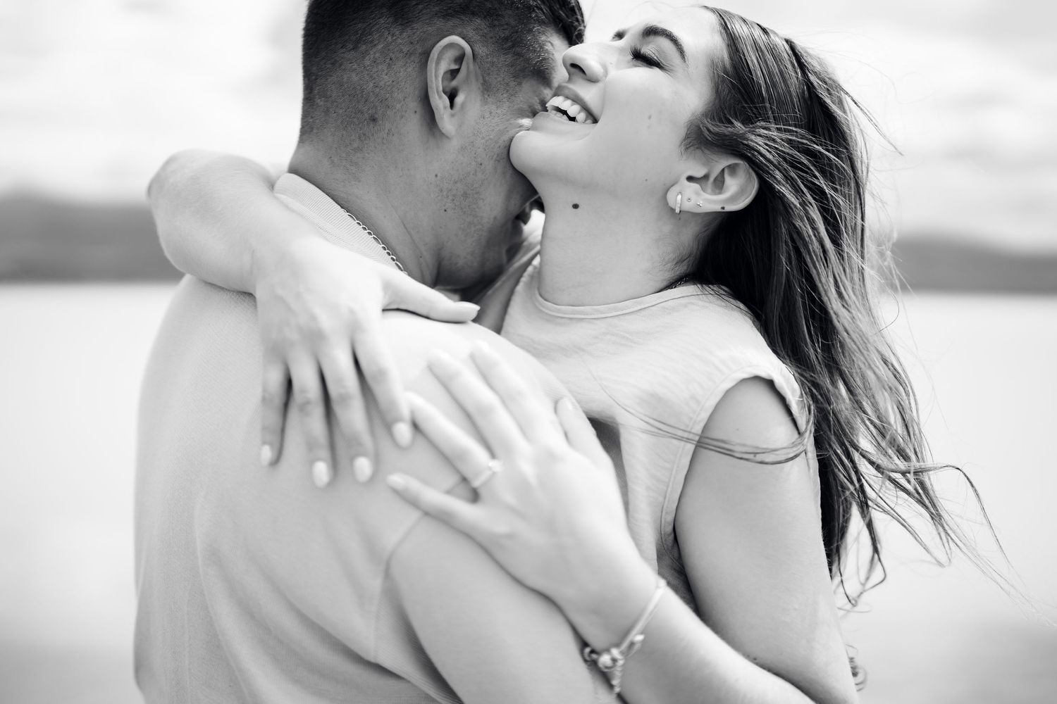 Romantic black and white beach photoshoot capturing intimate moments and tender embraces.