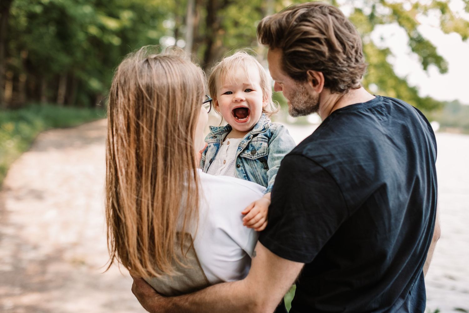 Candid family moment captured on forest trail during outdoor photo session.