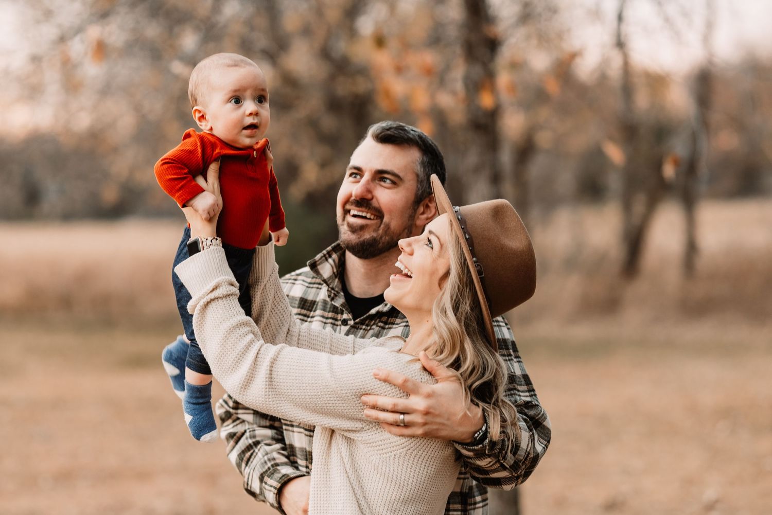 A heartwarming family moment outdoors during autumn with plaid shirt and cozy sweater fashion.