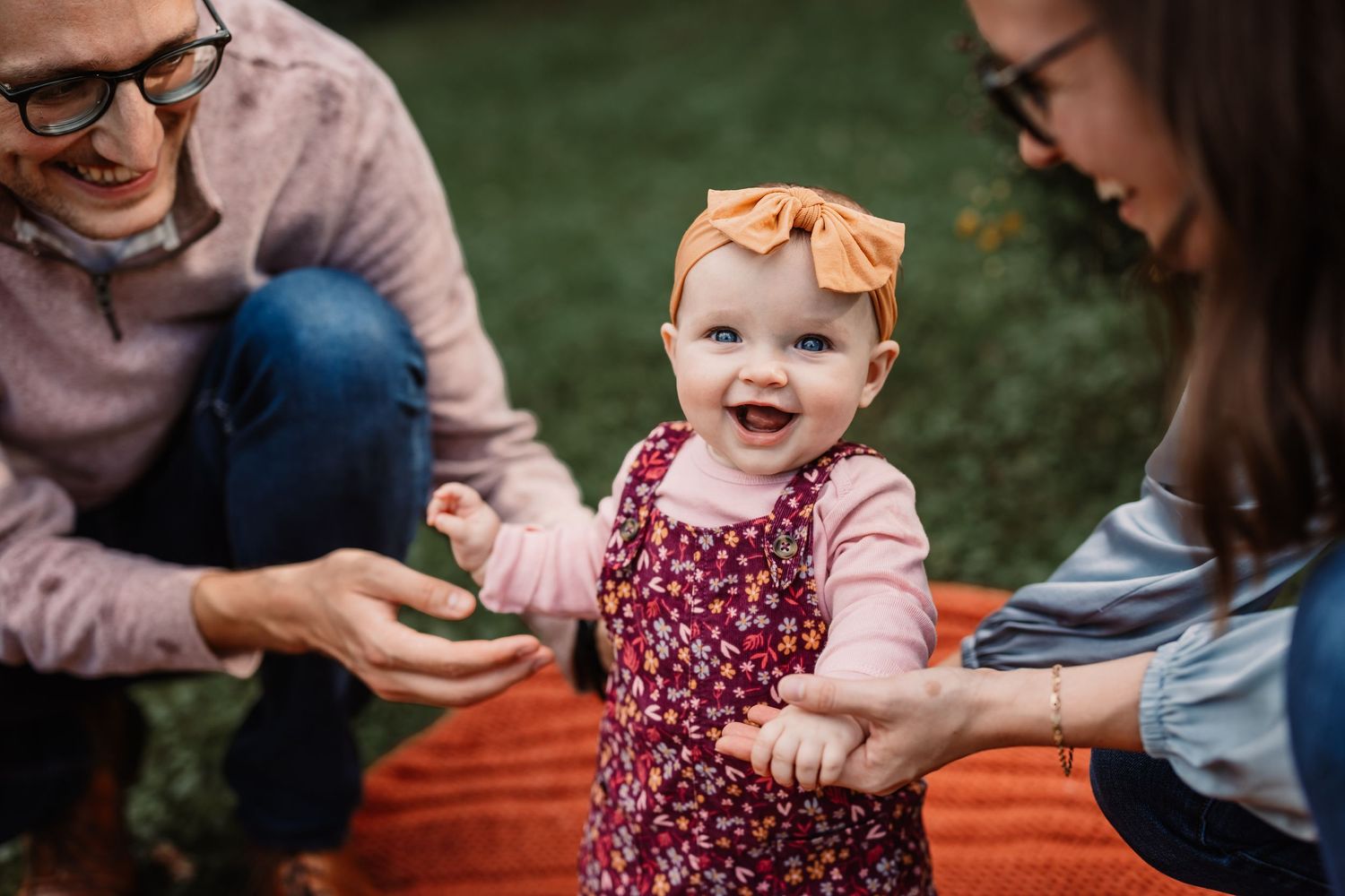 Heartwarming outdoor moment on orange blanket during fall photo session.