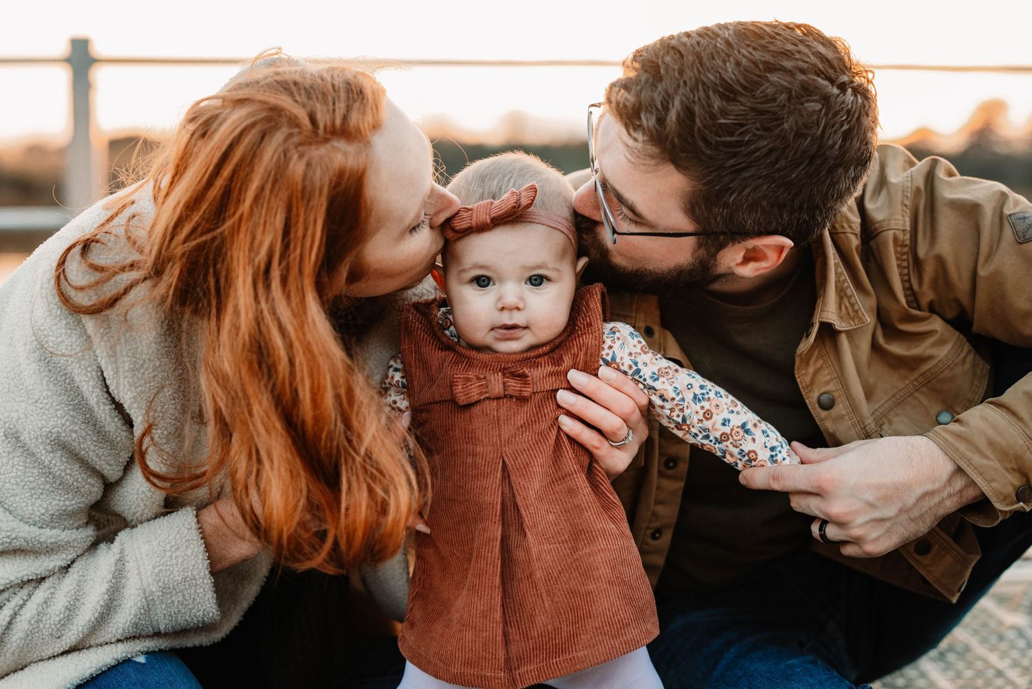 Family shares intimate moment outdoors during fall photoshoot.