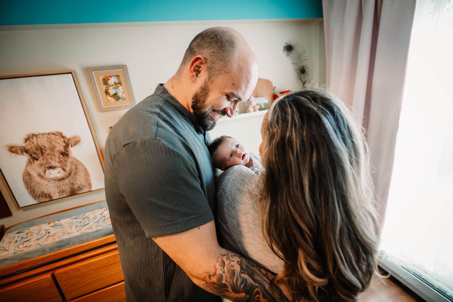 Intimate black and white portrait of couple sharing tender close moments together in nursery setting.