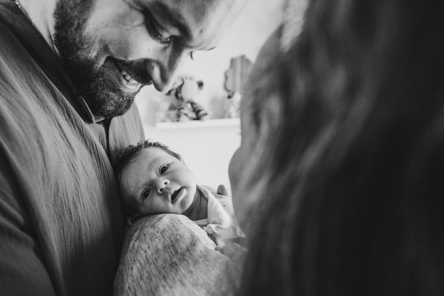 Artistic monochrome close-up captures tender moment between couple in soft natural light.