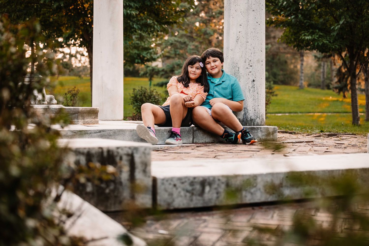 Couple sitting romantically together on a concrete structure in a scenic outdoor park setting during autumn.