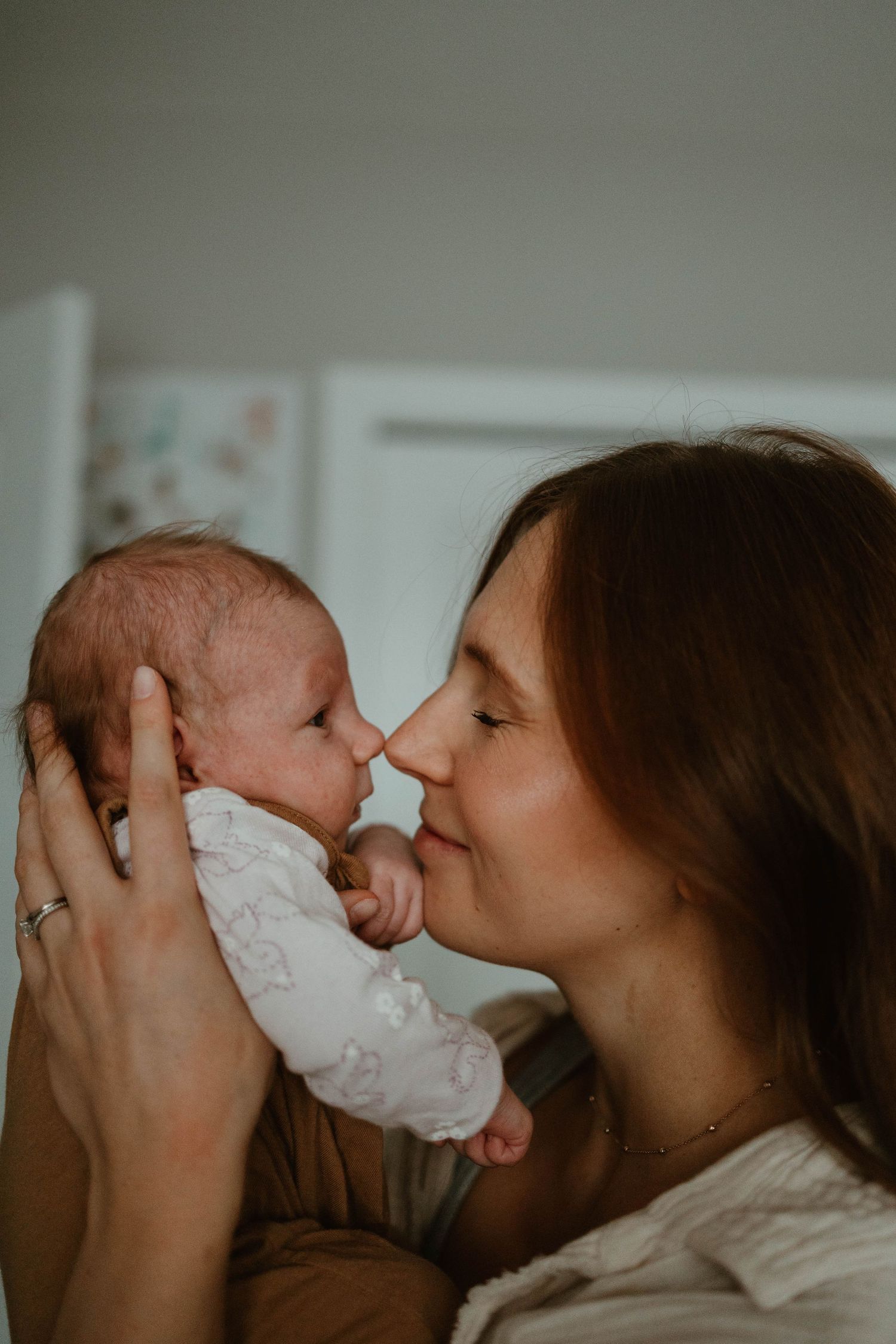Tender close-up moments between parent and newborn in natural window light.