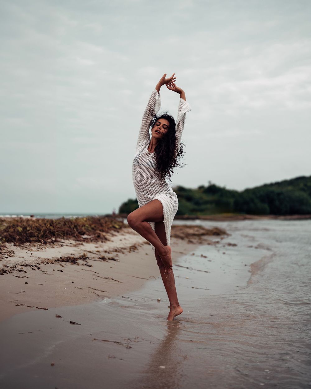 Four artistic photographs show a dancer moving gracefully along a misty beach shoreline in a white dress.