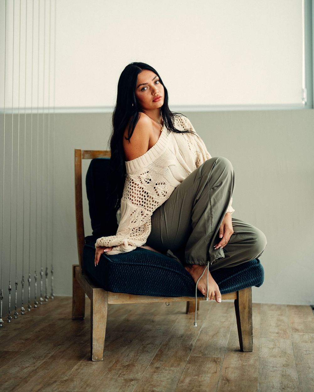 Series of artistic indoor portraits showing relaxed poses on a wooden chair in a minimalist studio setting.