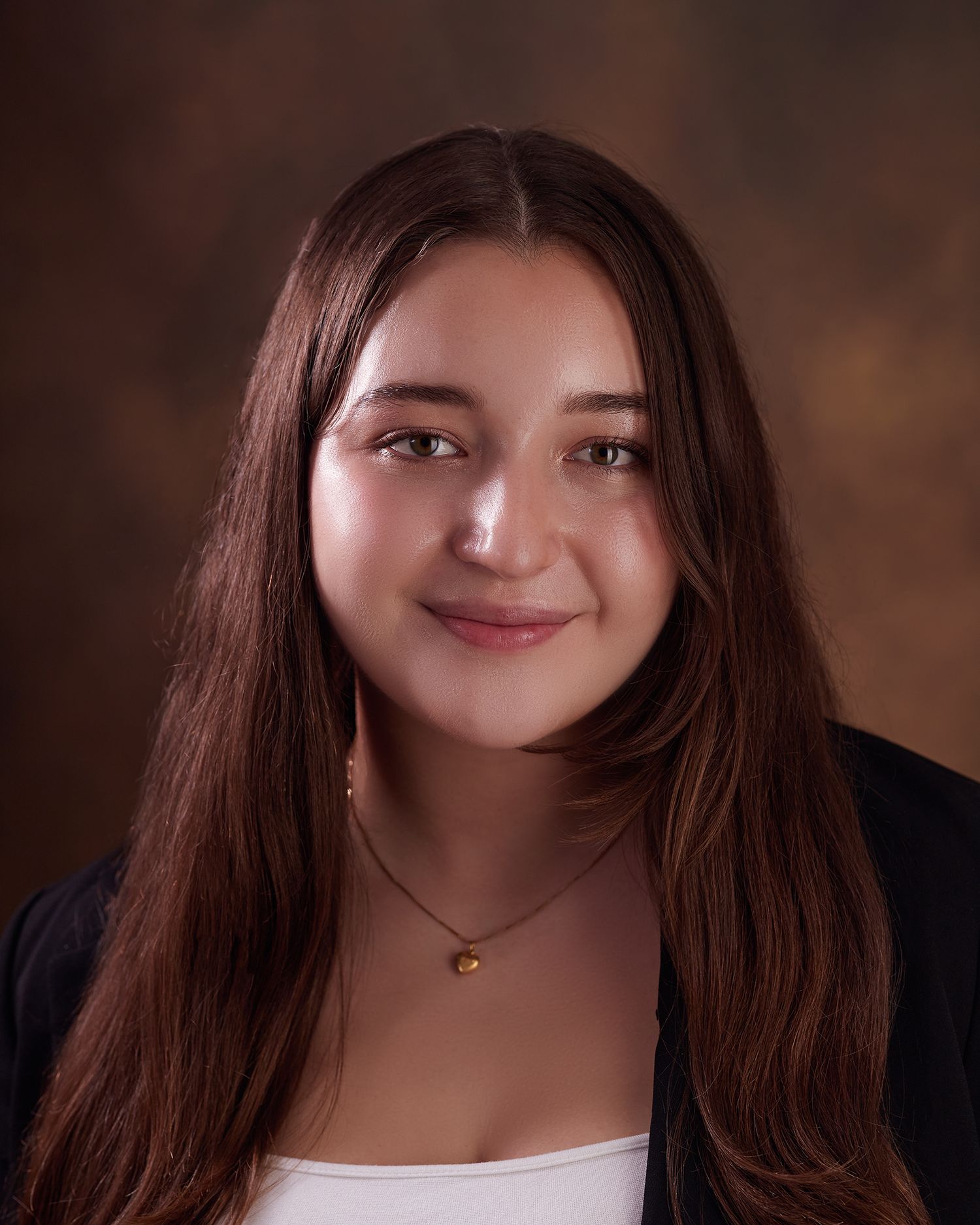 A studio portrait with warm lighting and brown background.