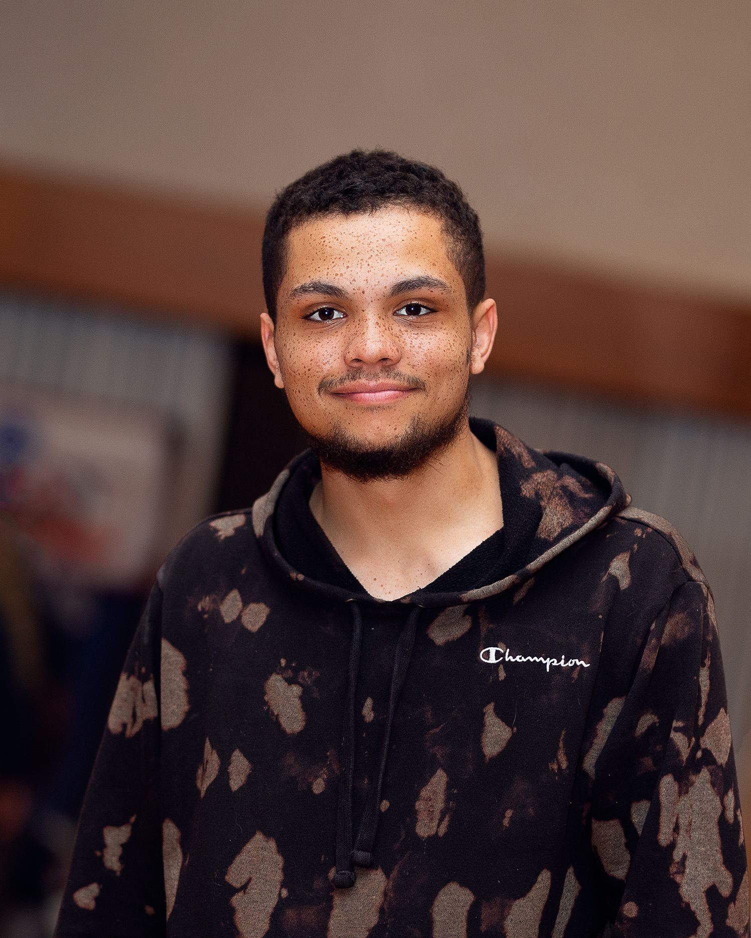 Casual portrait of someone in a camouflage-patterned Champion hoodie.