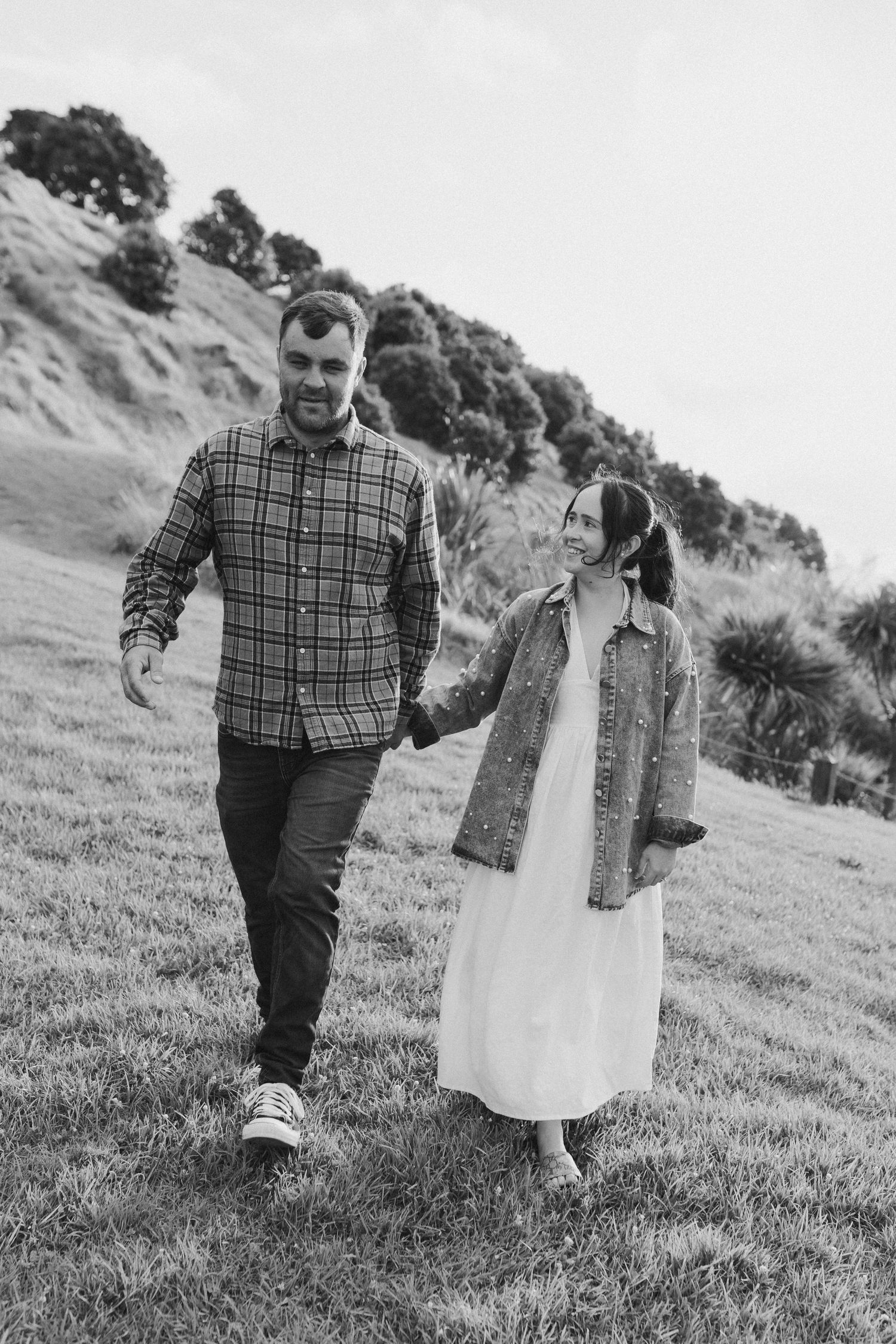 Couple holding hands walking together for engagement shoot in Auckland