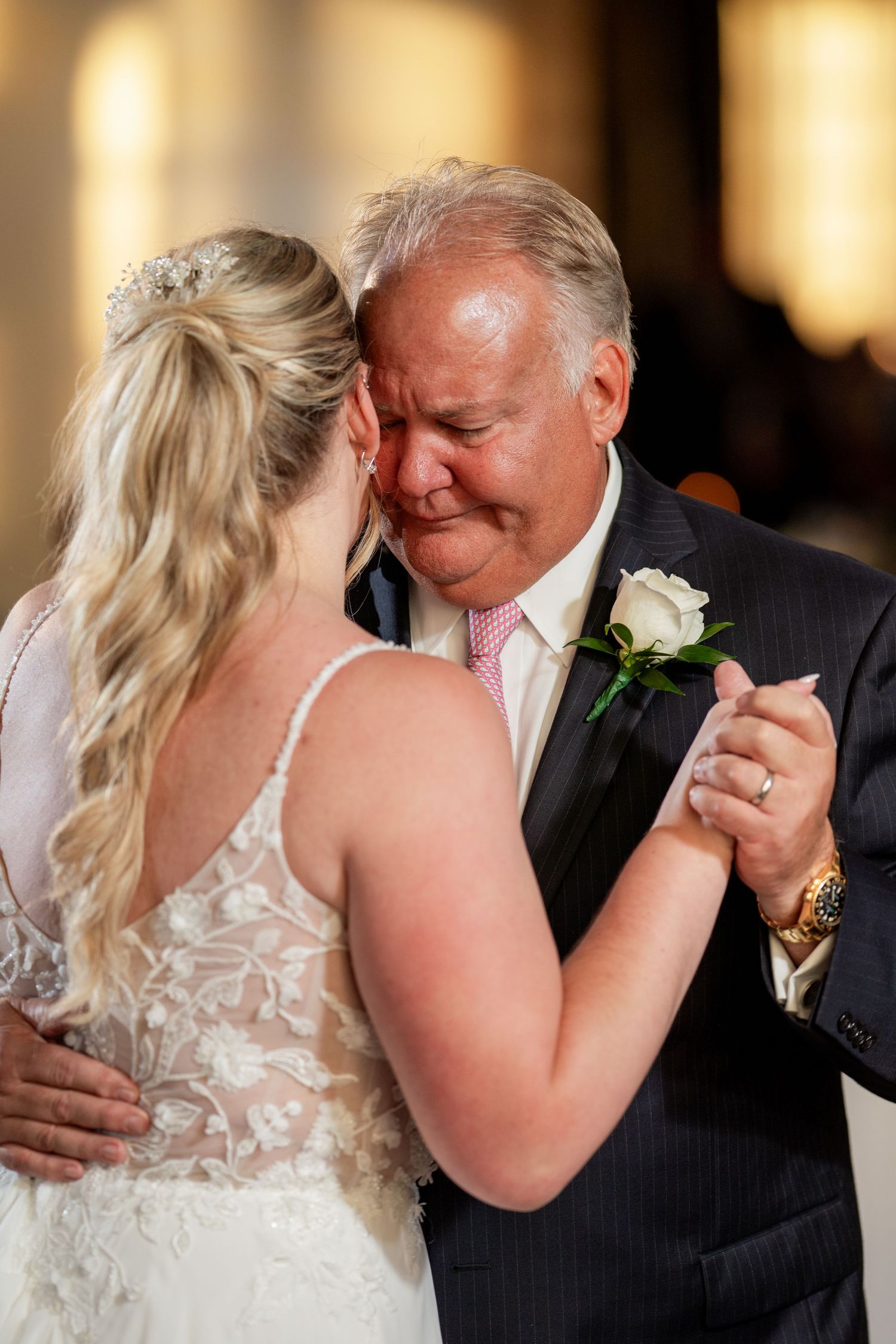 Emotional portrait of father and daughter dancing on her wedding day.