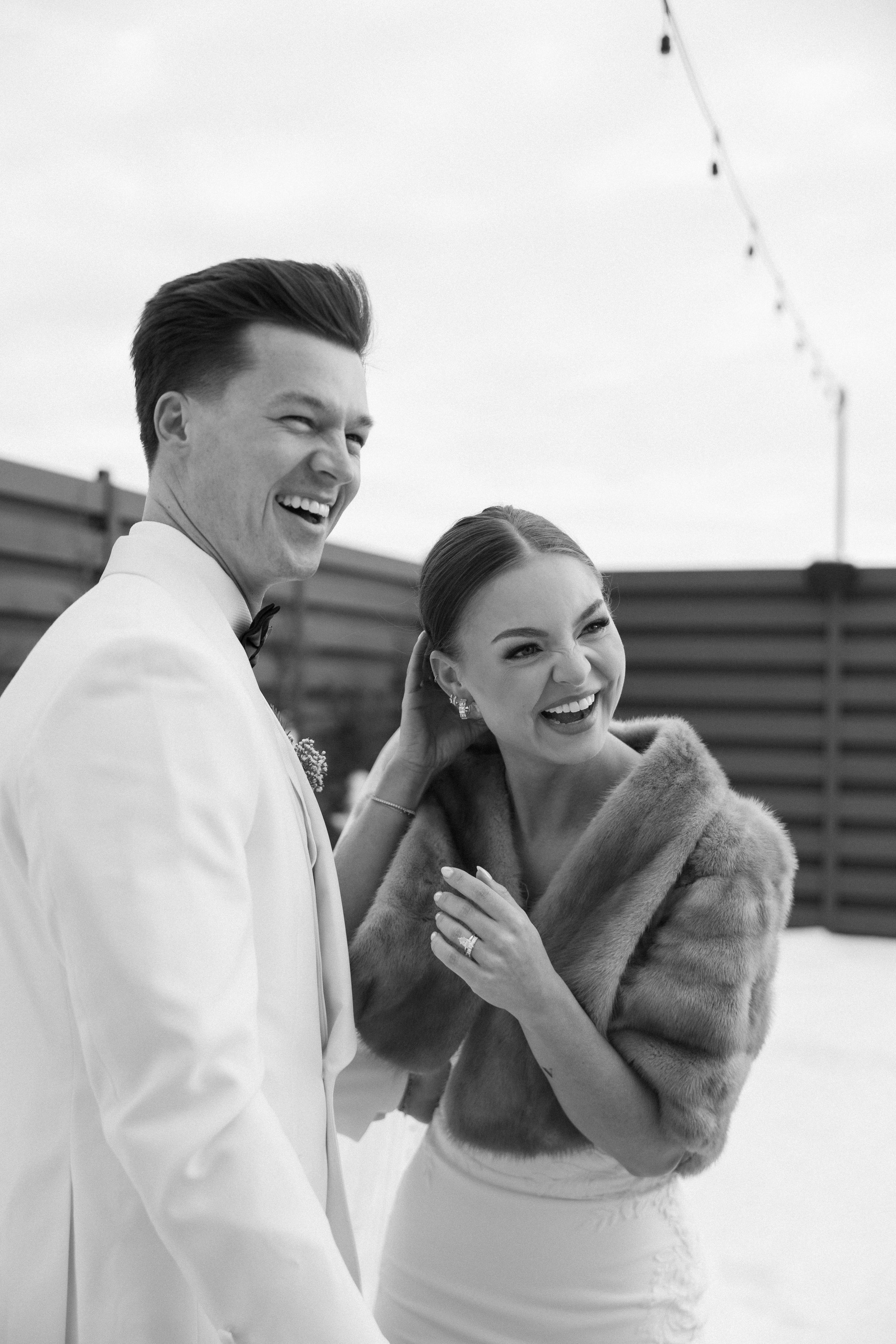 A couple in wedding attire share joyful laughter together in a series of black and white candid moments.
