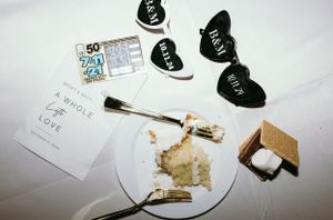 Wedding reception table with partially eaten cake and decorative hearts.