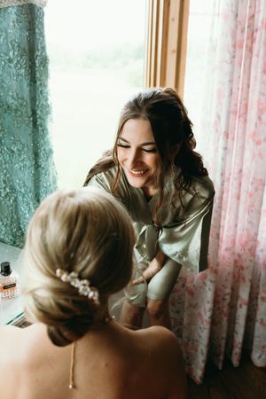 Two people in an intimate and tender moment together near sheer curtains in soft natural lighting.