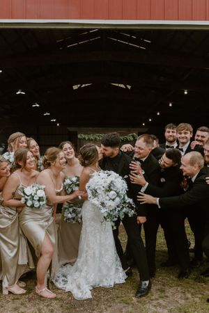 Wedding party group photo with bridesmaids in champagne dresses and groomsmen in black suits.