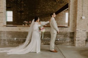 Romantic first look between couple in rustic brick venue on their wedding day.