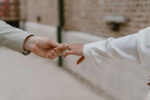 Close-up of two hands reaching toward each other in an intimate moment.