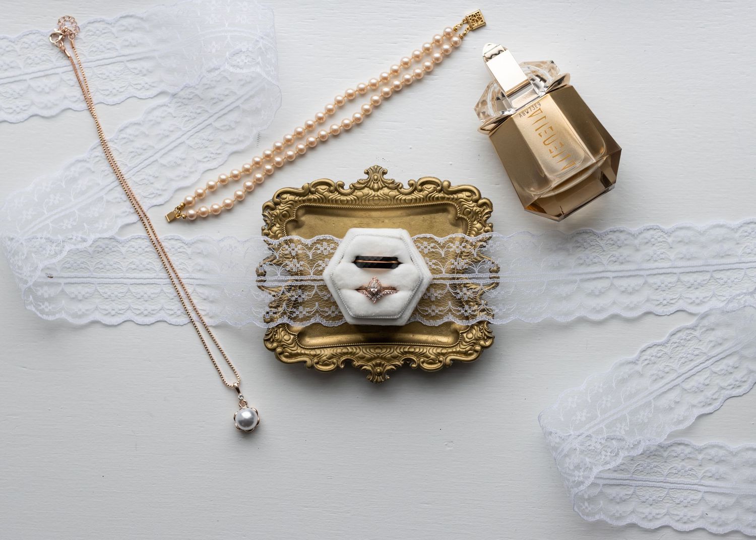 Delicate jewelry pieces including necklaces and pendants displayed on white lace fabric.