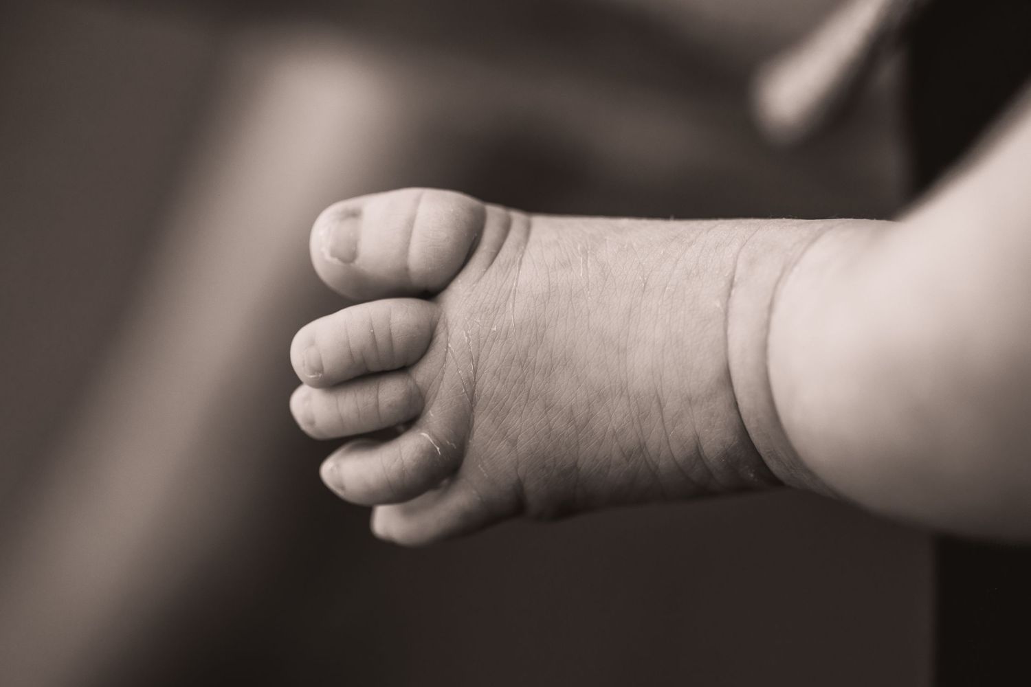 Black and white series showing close-up details of tiny baby hands and fingers.