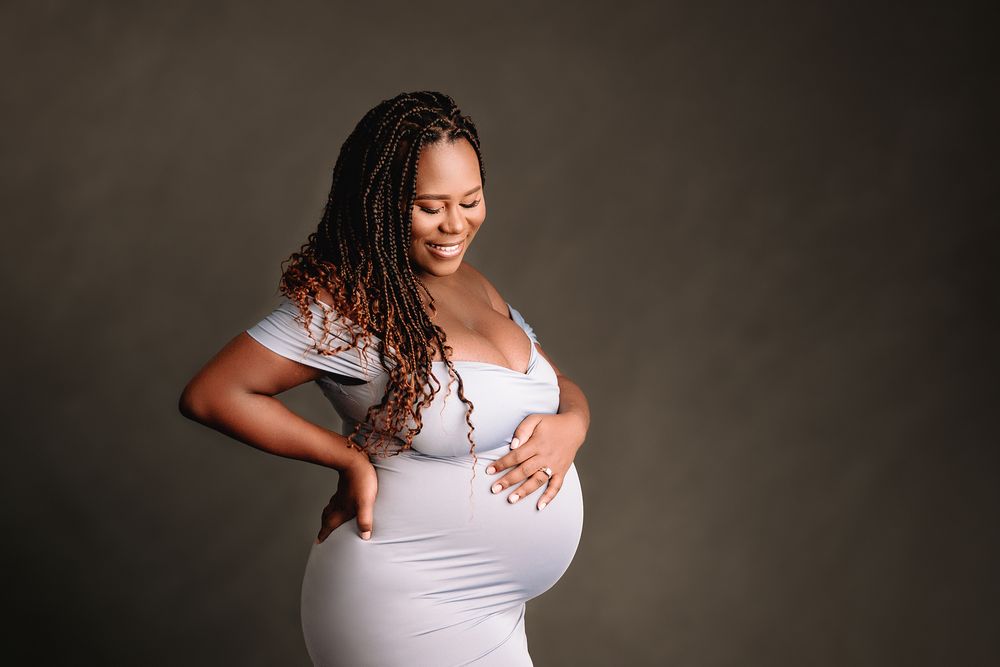 kansas city studio maternity photography mom smiling and pregnant belly