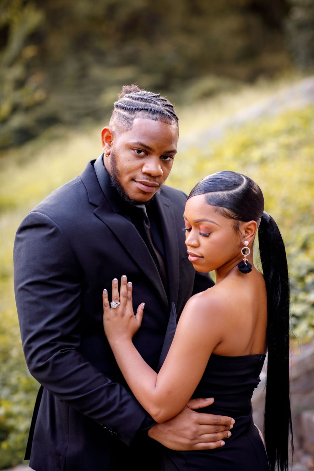 A romantic couple's portrait showing tender embrace in matching dark formal wear.