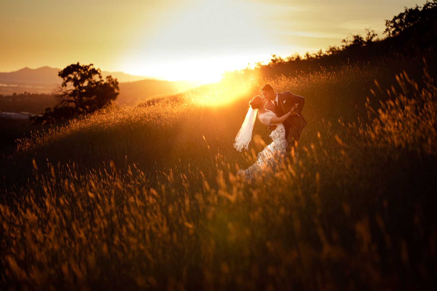 Couple dancing in a field on a mountain side at sunset.  Bridal, first look, formal session.