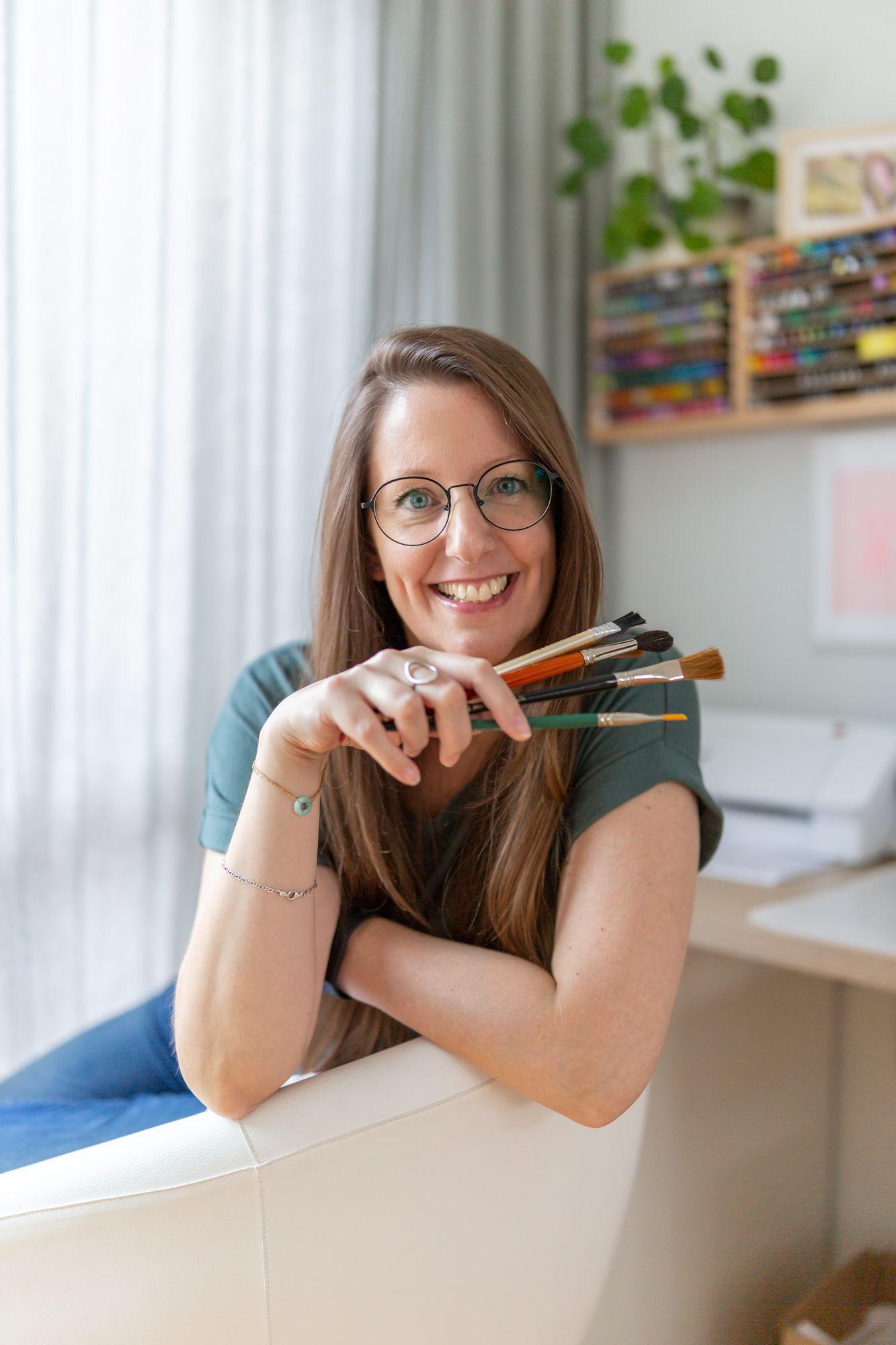 Creative portrait by window with art supplies and bright natural lighting.