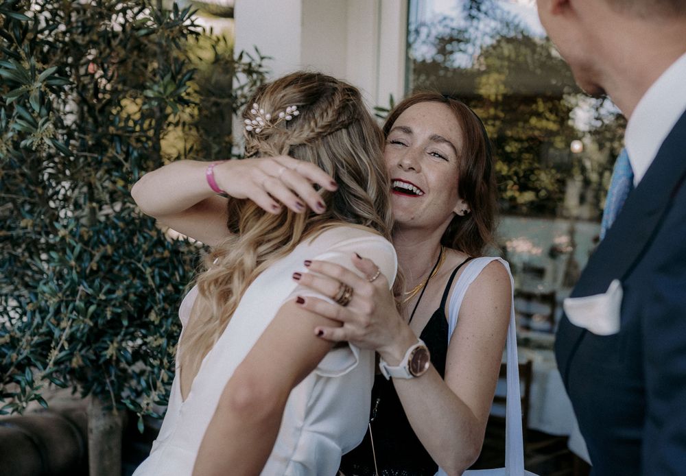 Candid moment of laughter and hugs during an outdoor celebration.
