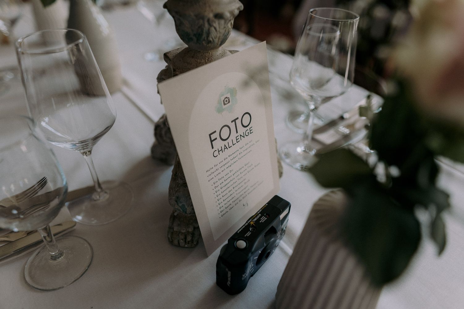 Elegant table setting with wine glasses and FOTO menu card.