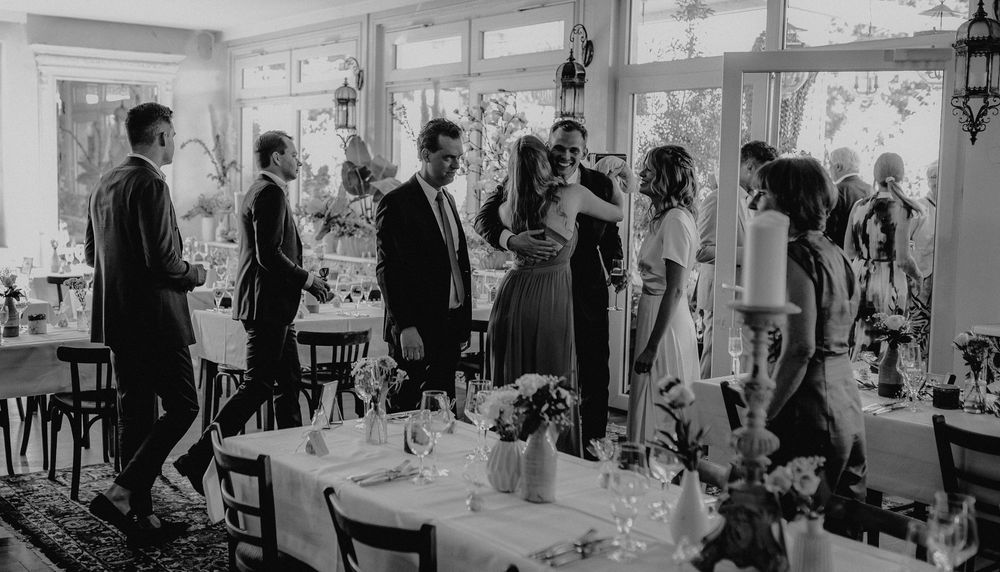 A vintage black and white photo of people gathered for a formal dining event in an elegant room.