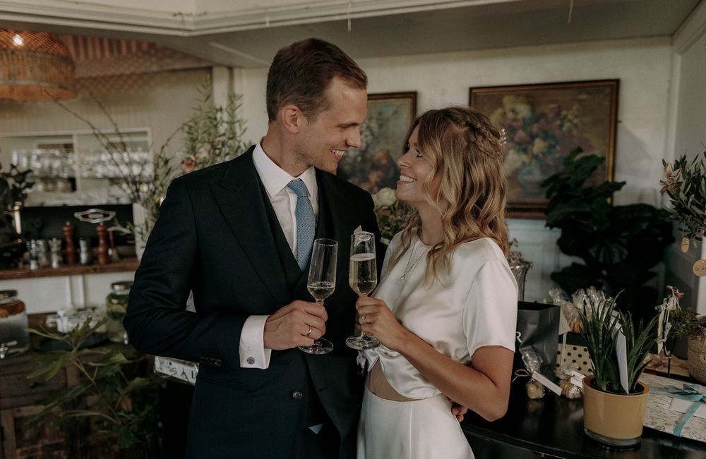 A couple enjoying champagne together in a restaurant with indoor plants and decor.