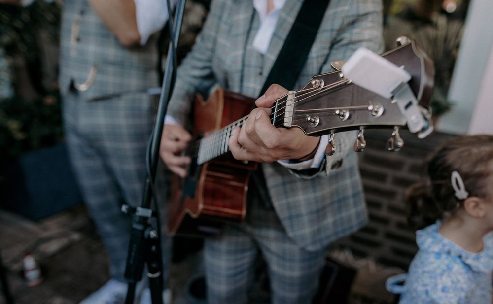 A musician playing acoustic guitar at an outdoor event.