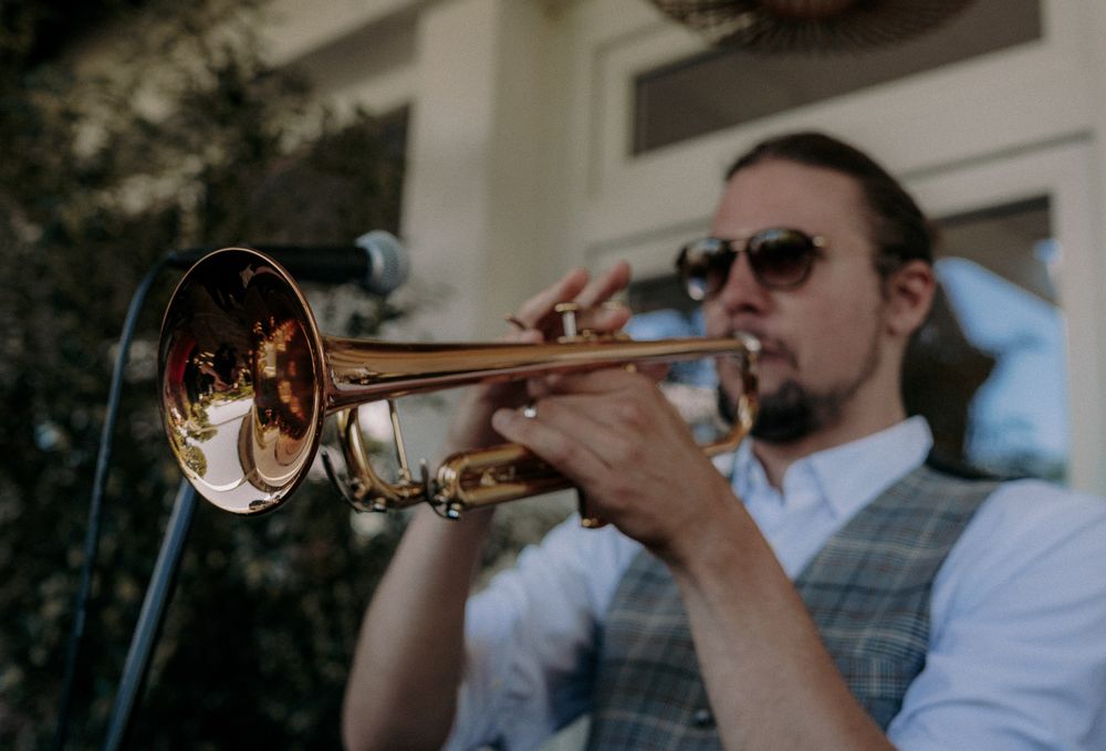 A trumpet player performing on stage with a microphone.
