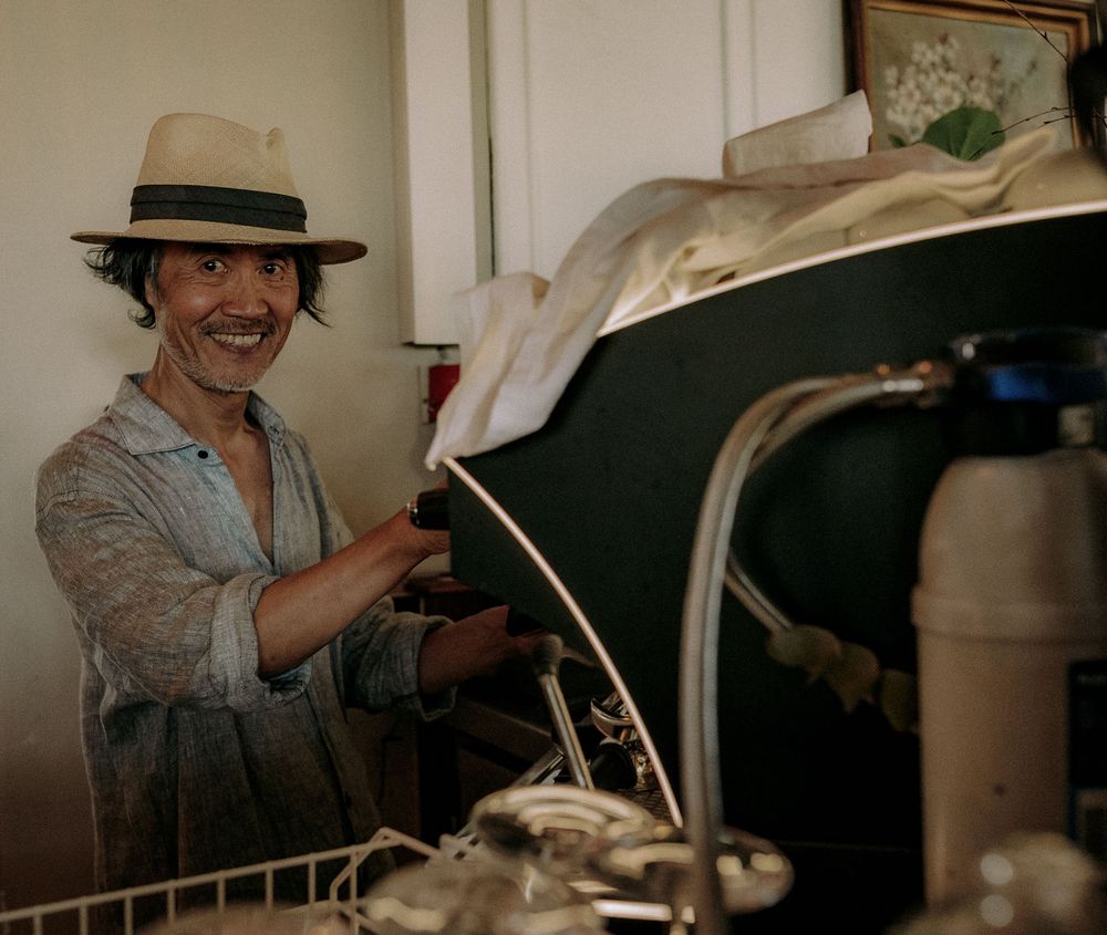A person in a hat doing dishes in a kitchen interior.