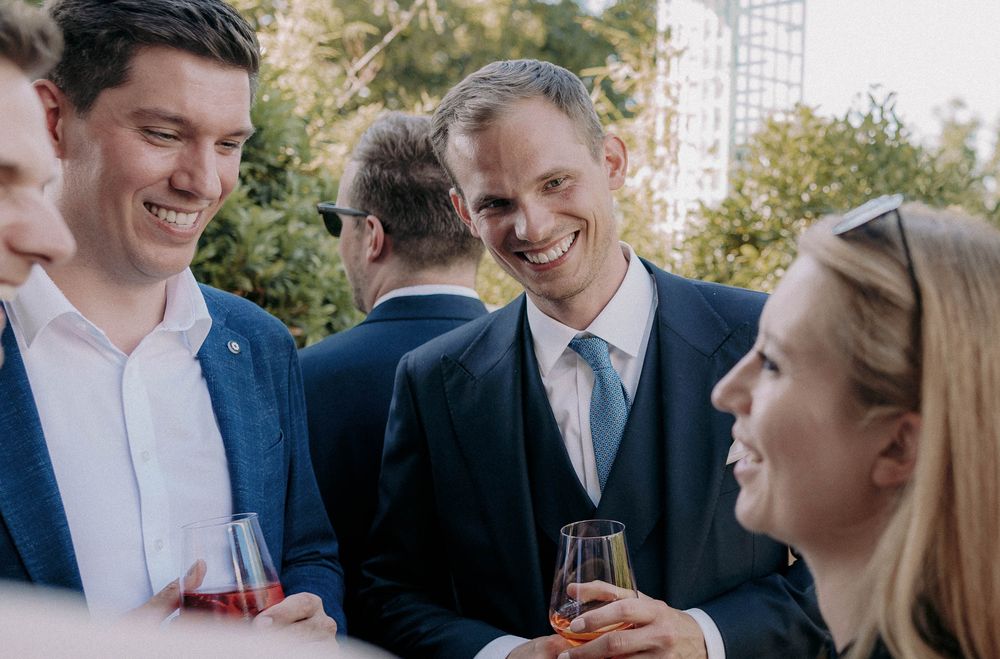 A group of guests enjoying drinks and conversation at an elegant outdoor gathering.