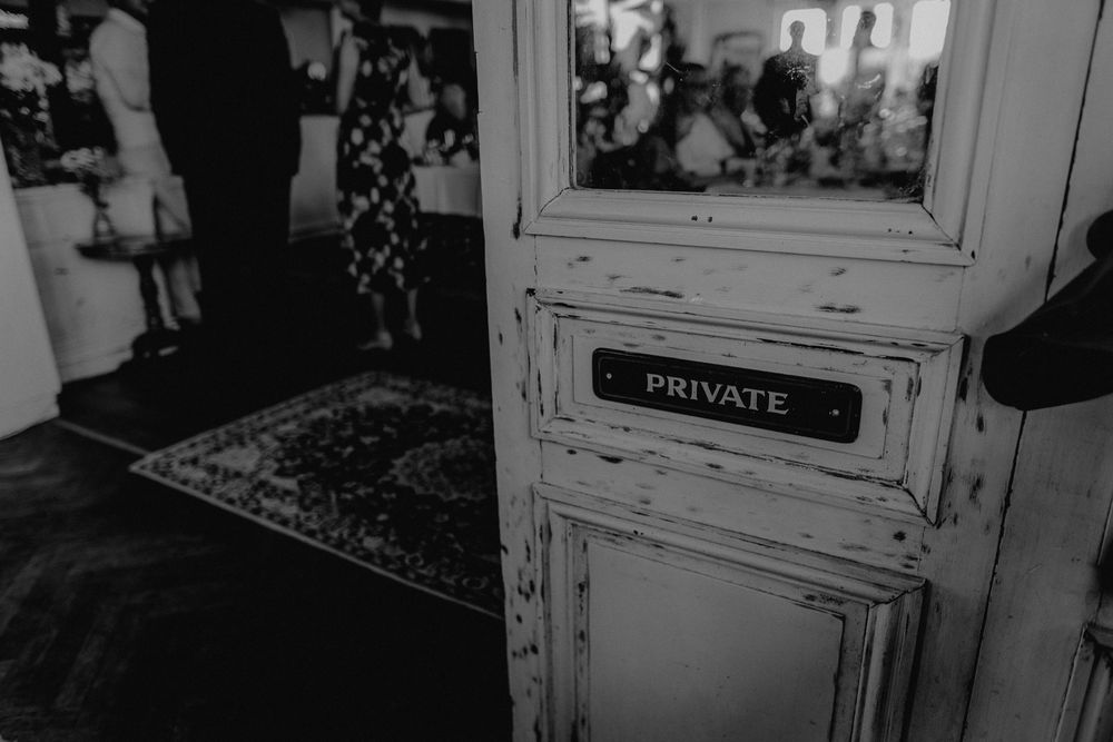 A vintage white door with a private sign in black and white.