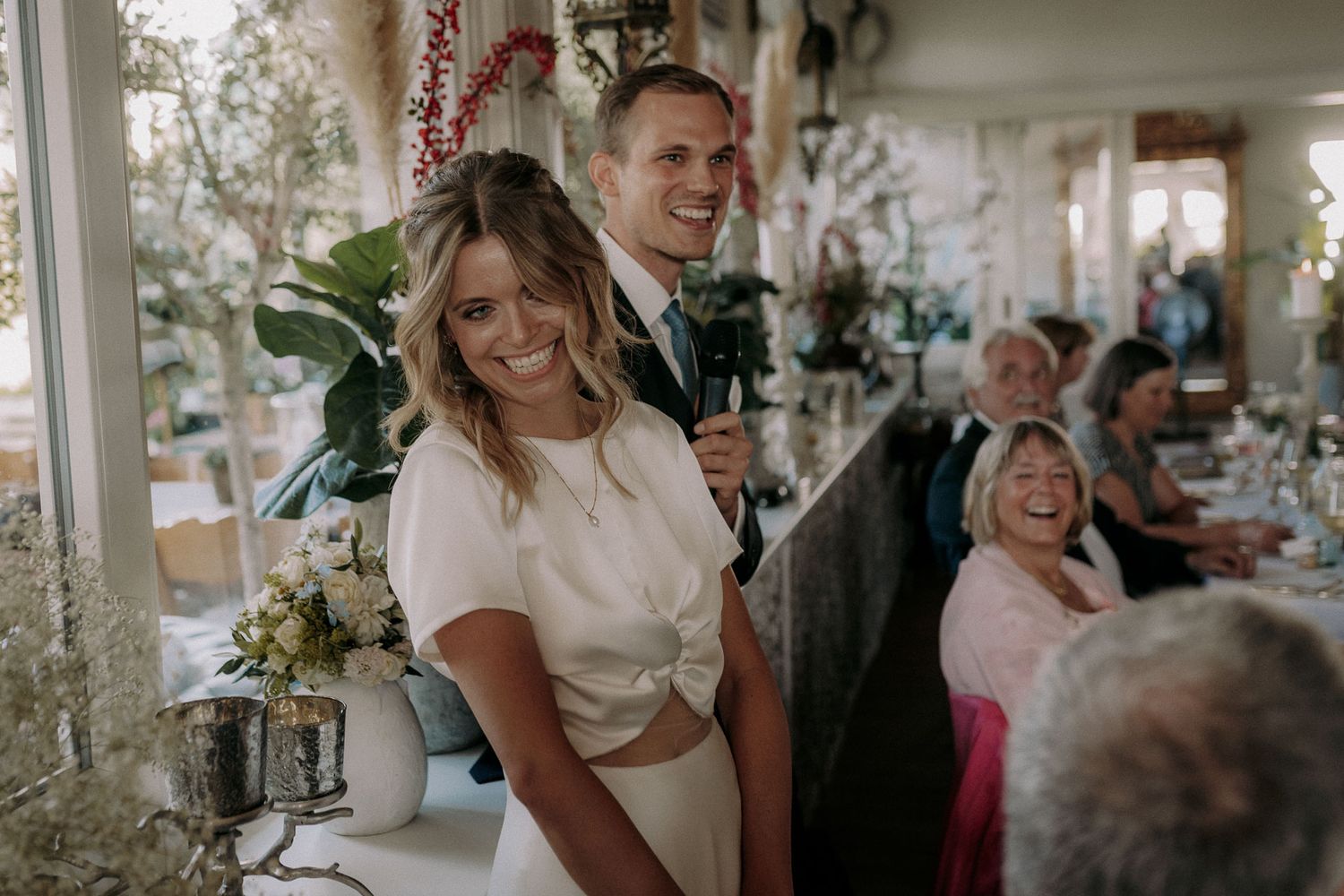 Joyful celebration moment at an indoor wedding reception with elegant decor.