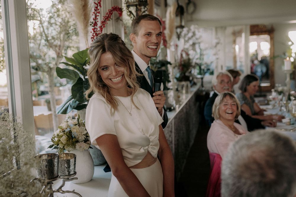 Joyful celebration moment at an indoor wedding reception with elegant decor.